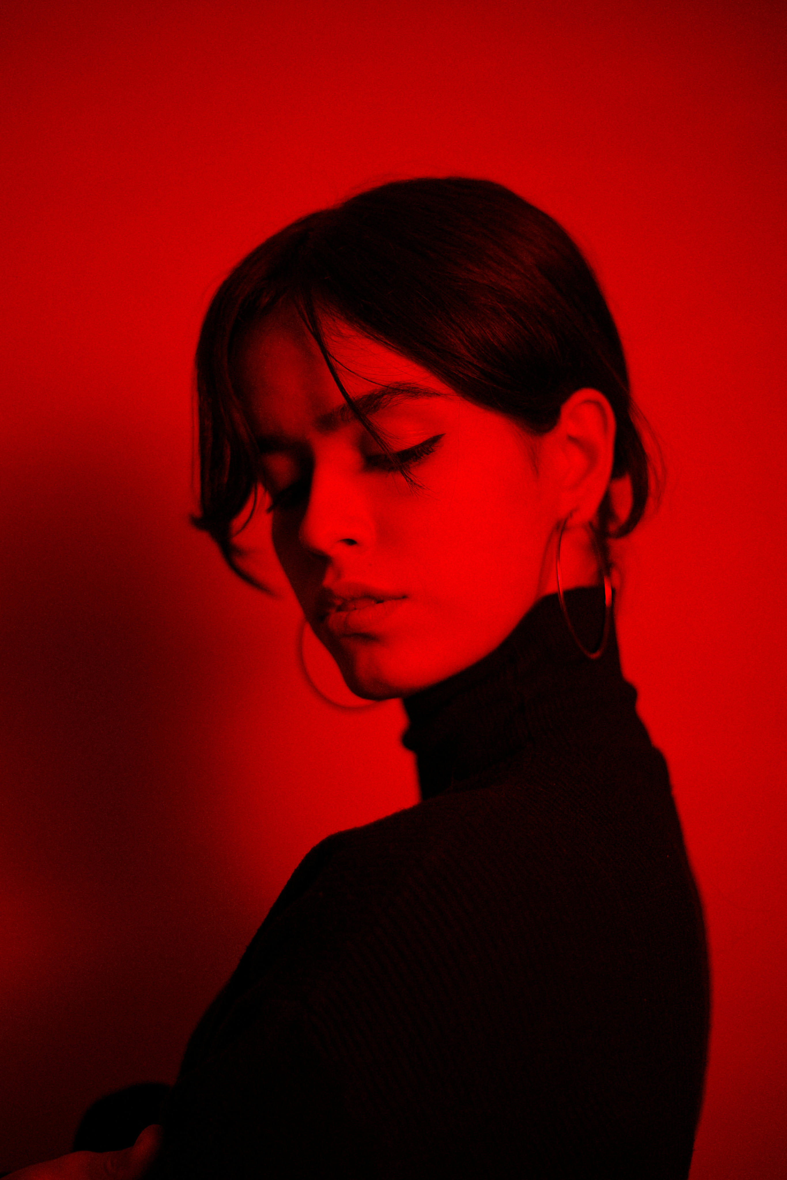 Young woman in profile with dramatic red lighting